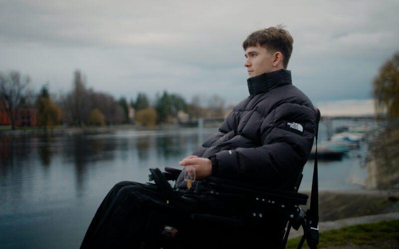 Das Foto zeigt Jannis Pagels, wie er mit seinem Rollstuhl am Seerhein steht.