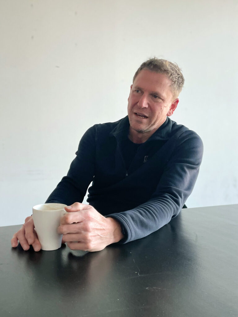 Das Bild zeigt den Stadtsportverbandsvorsitzenden Martin Müller an einem Tisch sitzend mit einer Tasse Kaffee in der Hand.