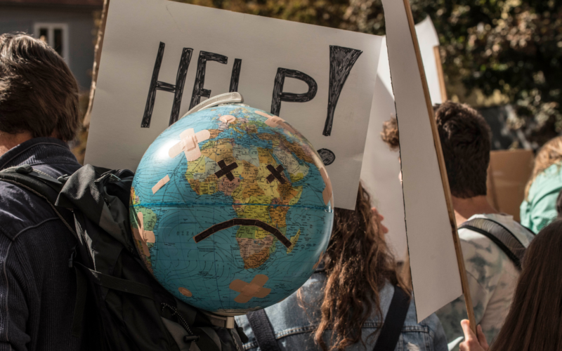 Das Bild zeigt einen Globus auf den ein trauriges Gesicht geklebt ist. Es ist bei einer Klimaschutzdemonstration entstanden.