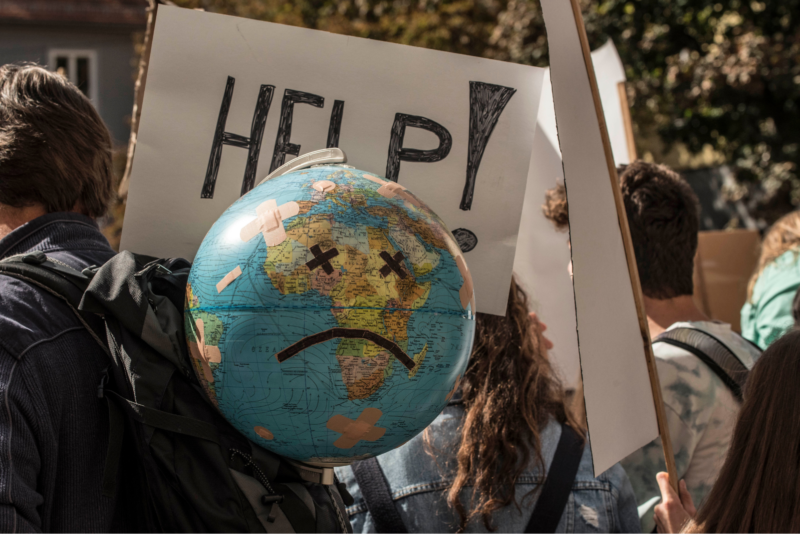 Das Bild zeigt einen Globus auf den ein trauriges Gesicht geklebt ist. Es ist bei einer Klimaschutzdemonstration entstanden.