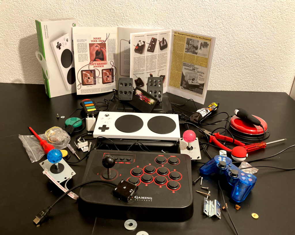 Das Foto zeigt Spielutensilien wie Controller und Spielkonsolen.